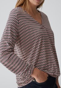 Bedruckte Bluse mit langen Ärmeln, V-Ausschnitt, rosa und schwarzen geometrischen Mustern, weichem Stoff und elastischen Bündchen.