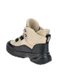 Bota beige y negra con cuello acolchado, suela exterior de goma negra texturizada, parte superior bicolor y cordones; presenta un logotipo en la parte trasera.