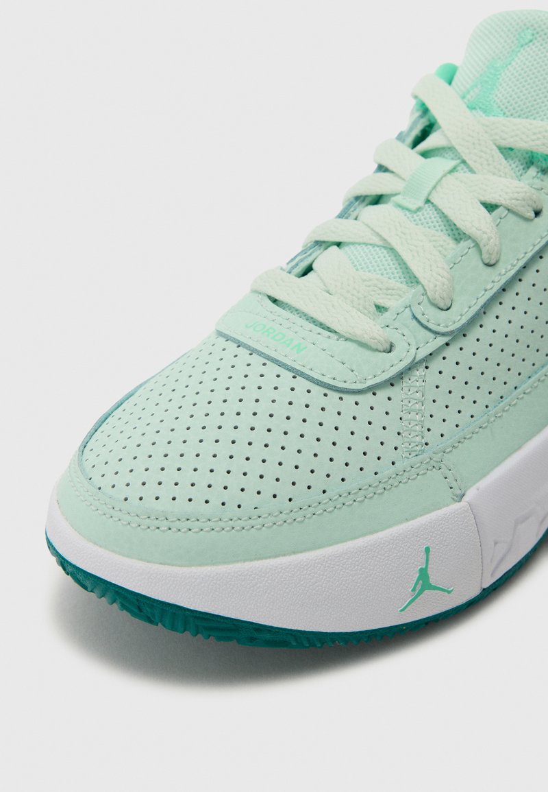 Baskets vert clair avec tige perforée, lacets, et une semelle intermédiaire blanche avec un accent teal et le logo Jordan sur le côté.