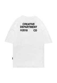 Weißes, übergroßes T-Shirt mit kurzen Ärmeln, das auf der Rückseite in auffälliger Schrift den schwarzen Text: "CREATIVE DEPARTMENT ®2018 CD" trägt.