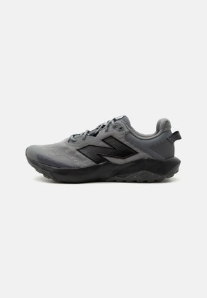 Baskets New Balance grises et noires avec tige en mesh, fermeture à lacets, col rembourré et semelle robuste pour la course sur sentier.