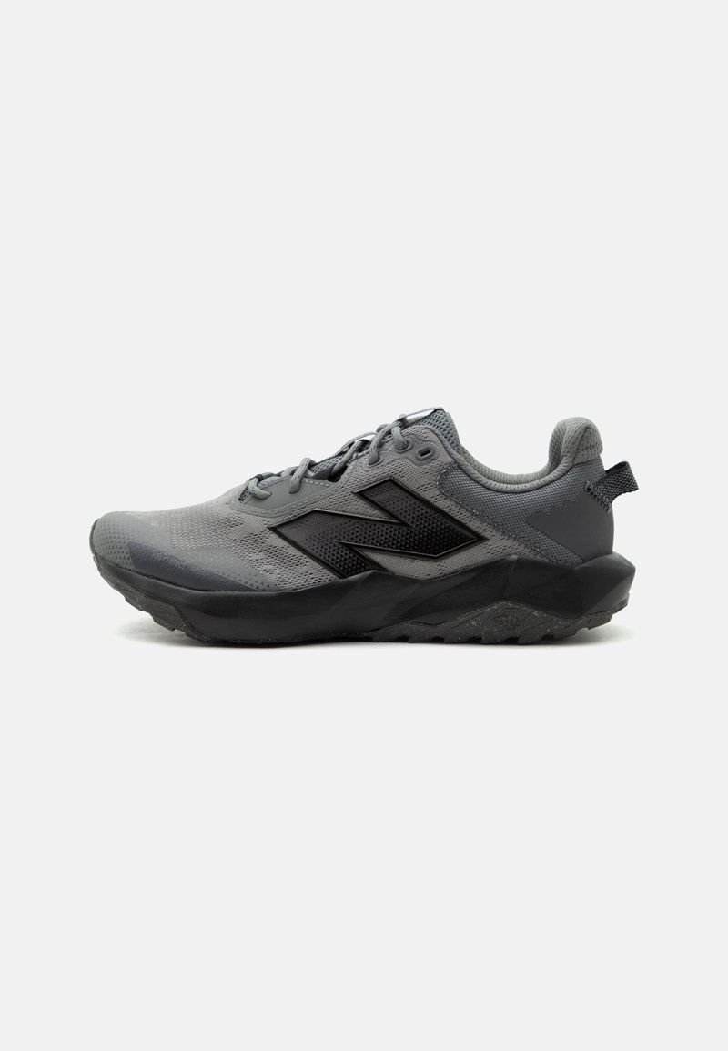 Γκρι και μαύρο sneaker New Balance με επάνω μέρος από δίχτυ, κλείσιμο με κορδόνια, επενδυμένο γιακά και ανθεκτική σόλα για ορεινό τρέξιμο.
