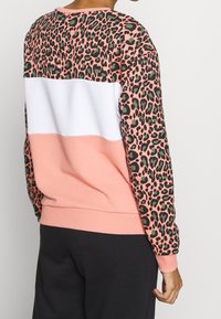 Felpa color block in rosa, bianco e stampa leopardata. Presenta polsini e orlo a coste, con una vestibilità comoda e una texture morbida.