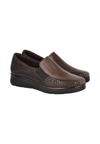 Zapatos marrones tipo slip-on con una parte superior de cuero suave y paneles laterales con textura, suela acolchada y detalles elásticos en la entrada.