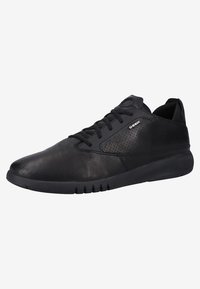 Svarta sneakers med en slät läderöverdel, perforerade detaljer på sidan och gummisula med spår för grepp.