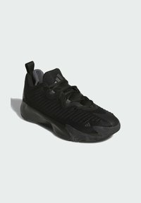 Zapatilla deportiva negra con parte superior de malla texturizada, cierre con cordones, suela de goma y sutiles detalles de marca en el lateral y el talón.