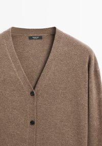 Bruine cardigan gemaakt van zacht breiwerk, met een V-hals, lange mouwen en drie zwarte knopen aan de voorkant. Minimalistisch ontwerp.