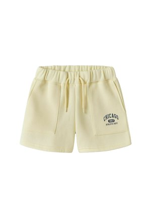 Lys gule casual shorts med elastisk midjebånd, snor, frontlommer og "Chicago 1987 Athletic Dept." trykt på venstre lomme.