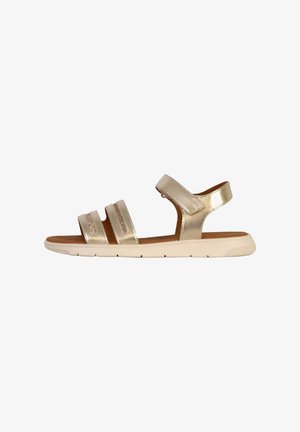 Gold metallic sandals with three adjustable straps, a cushioned footbed, and a white rubber sole. Flat design for easy wear.
