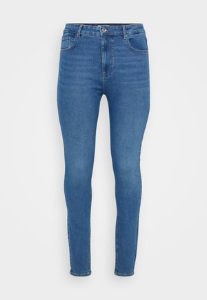 Jean skinny en denim bleu avec une taille haute, design classique à cinq poches et une décoloration subtile. Doté d'une fermeture à bouton métallique et à zip.