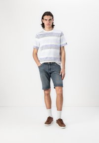 Camisa de manga corta a rayas azul claro y blanca, pantalones cortos de mezclilla, zapatos marrones y calcetines blancos. Diseño simple, atuendo casual de verano.