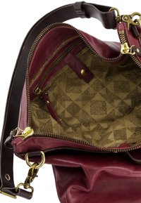 Bordeaux lederen tas met een beige patrooninterieur. Voorzien van gouden hardware, ritssluitingen en een gladde textuur.