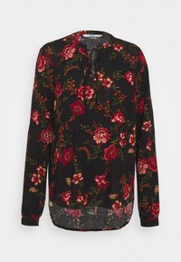 Schwarze Bluse mit langen Ärmeln und floralem Muster in Rot und Grün, mit rundem Halsausschnitt und Bindeband vorne. Der Saum ist hinten länger.