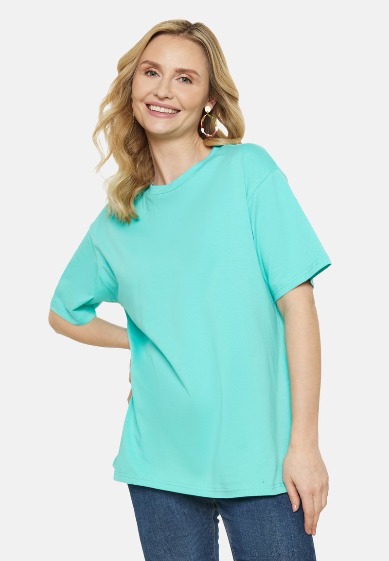 Turkosa överdimensionerad t-shirt i bomull, med rund hals och korta ärmar. Slät textur, minimal sömdetaljering.