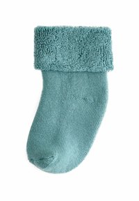 Türkise Socke mit einem flauschigen, strukturierten Bündchen. Hergestellt aus weichem Material, hat der Schaft ein glattes, geripptes Design.