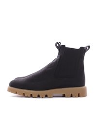 Bottines noires en tissu, avec un design à enfiler, des panneaux élastiques sur les côtés, et une semelle en caoutchouc épaisse avec un relief texturé.