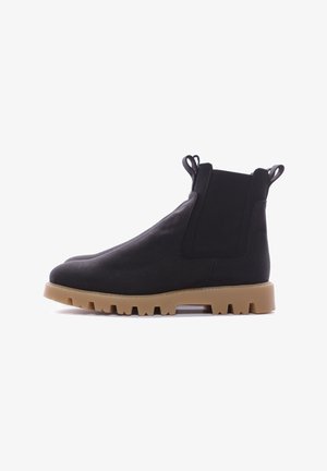 Stivaletti neri alla caviglia realizzati in tessuto, con design slip-on, pannelli elastici laterali e suola in gomma spessa con battistrada testurizzato.