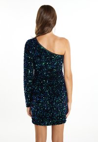 Krátké šaty na jedno rameno s přiléhavým střihem vyrobené z tmavé tkaniny zdobené odrazivými modrými a zelenými flitry. Hladký výstřih a rukáv.