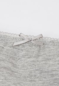 Šedá látka s jemnou strukturou, zdobená jemnou krajkovou lemovkou a malou stříbrnou stuhou na pásu.