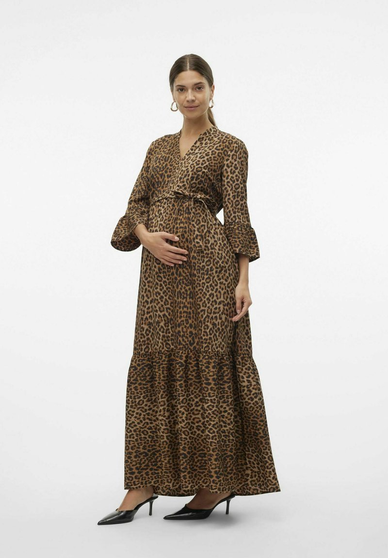 Maxiklänning med leopardmönster i brun och svart, med draperad design, lager på lager-nederdel och utsvängda ärmar, tillsammans med svarta spetsiga klackar.