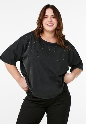 Sort kortærmet T-shirt med løs pasform, prydet med spredte sølv- og sorte udsmykninger på forsiden. Rund halsudskæring, blød tekstur.