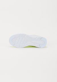 Sneaker sula i vitt gummi med texturerade spår och fåror för bättre grepp, med en antydan av neongrön vid hälen.