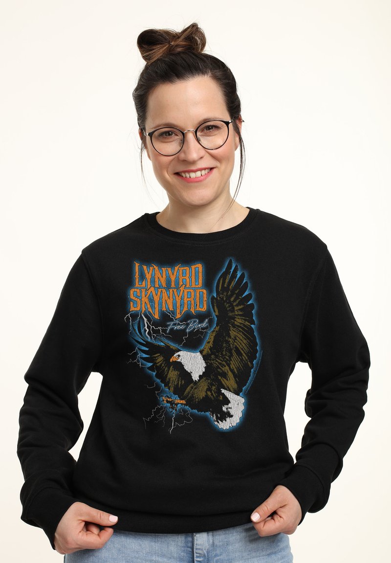 Černá mikina s grafikou orla a modrými akcenty s textem "LYNYRD SKYNYRD Free Bird." Hladký design s žebrovanými manžetami a výstřihem do krku.