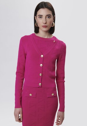 Fuchsia Strickjacke mit V-Ausschnitt, ausgestattet mit goldenen Knöpfen und geometrischen Mustern. Lange Ärmel, strukturierter Stoff, kurze Gestaltung.