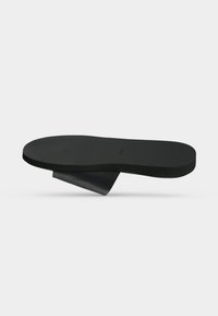 Semelle orthopédique noire avec support de voûte plantaire surélevé et surface supérieure texturée, conçue pour le confort et la stabilité du pied.