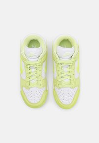 Paire de baskets montantes Nike blanches et vert clair vues du dessus avec lacets noués et zone des orteils perforée.
