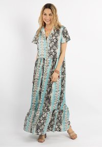 Rochie maxi cu un model de imprimare cu șarpelui în alb și negru, cu dungi verticale turcoaz, mâneci scurte și tiv ondulat.