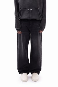 Svart oversized hettegenser med kengurulomme og grå vide jeans. Glatt tekstur, avslappet passform og minimalistisk design uten synlig merkevare.