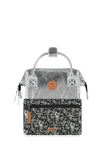 Silver metallic bag with a top handle and zipper closure, featuring a detachable black pouch with white graphic designs and a brown logo patch.