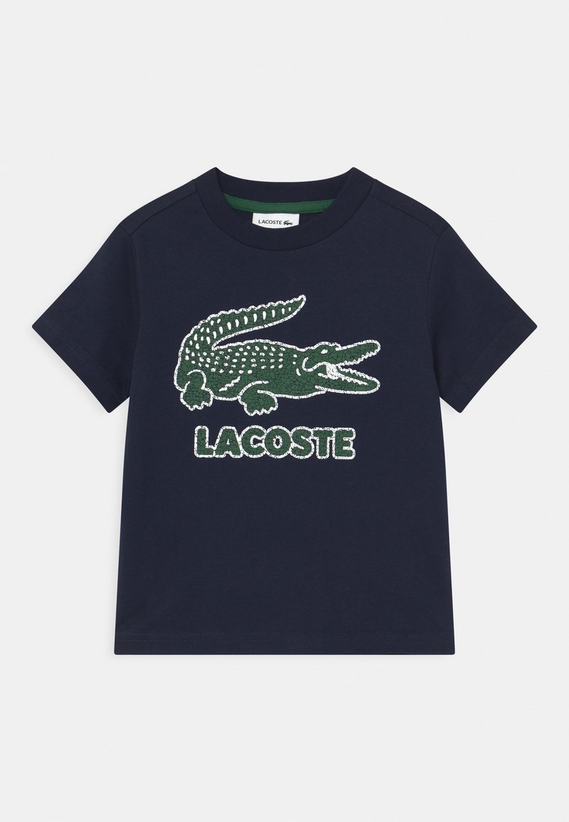 Navy Baumwoll-T-Shirt mit einem grünen Krokodil-Logo und erhabenem "LACOSTE"-Schriftzug. Kurze Ärmel und runder Ausschnitt.