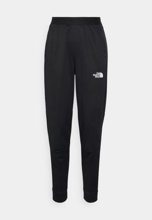 Czarne zwężane spodnie dresowe z elastycznym pasem, kieszeniami po bokach, przeszyciami na kolanach i białym logo The North Face na górnej części uda.