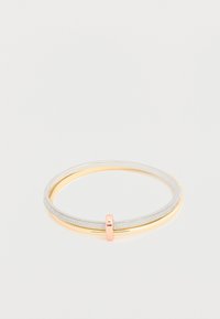 Bracelet double jonc avec un bracelet argenté pailleté et un bracelet doré, reliés par un petit fermoir en or rose sur fond blanc.