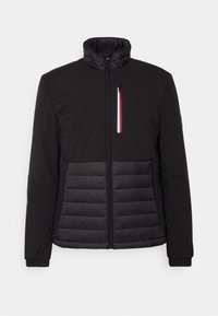 Black jacket with a high collar, featuring a puffy texture on the bottom half and a zippered pocket with red, white, and blue accents.