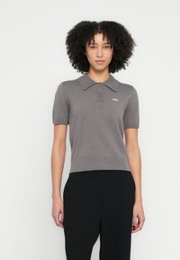 Szürke bordázott anyagú rövid ujjú galléros póló, háromgombos lezárással és a mellkason egy kis fehér "2ND" logóval.