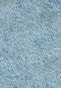 Tela de mezclilla azul claro con una textura suave, que presenta un sutil patrón deslavado y líneas de tejido en diagonal, típicas de la mezclilla clásica.