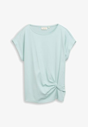 Blouse bleu clair à manches courtes avec un col rond et un détail noué torsadé sur le bas du côté droit.