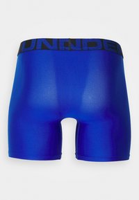 Boxer-briefs bleus en tissu lisse, avec une taille élastique noire comportant le texte "UNDER". Design court et ajusté sans motifs.