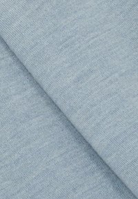 Világoskék szövet sima felületű, finom, egységes szövésű, minimális vizuális mintázattal, ferdén hajtva.