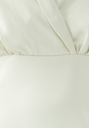 Ecrufarbenes Kleid aus strukturiertem Stoff. Verfügt über einen V-Ausschnitt und eine geraffte Taille, die eine glatte Silhouette schafft.