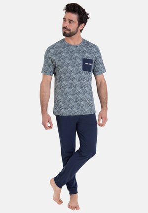 Ensemble de pyjama pour homme composé d'une chemise à manches courtes verte à motifs avec une poche poitrine et un pantalon à taille élastique bleu marine. Tissu doux.