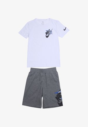 T-shirt blanc à manches courtes avec logo Nike noir et bleu. Short gris avec motif graphique noir et bleu sur le côté. Matière en mélange de coton.