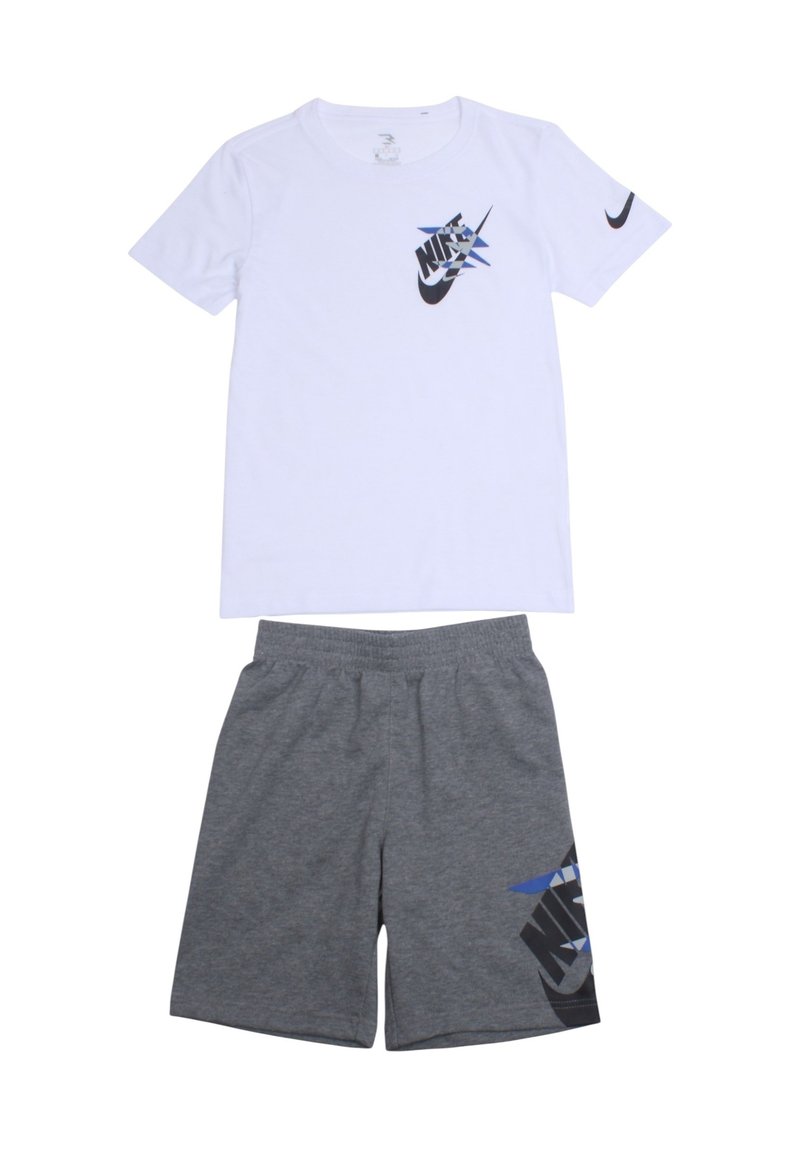 T-shirt blanc à manches courtes avec logo Nike noir et bleu. Short gris avec motif graphique noir et bleu sur le côté. Matière en mélange de coton.