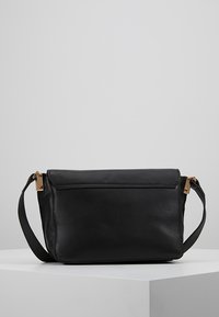 Schwarze Leder-Crossbody-Tasche mit strukturierter Oberfläche, goldenen Hardware-Details, Reißverschluss und abnehmbarem Schulterriemen.