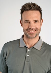 Harmaa poolopaita, jossa on tekstuuri, kaulus, jossa on vaalea kuvio ja kontrastivärinen beige viimeistely, sekä kolme nappia kauluksessa.