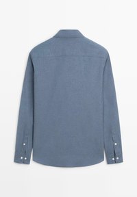 Světle modrá košile s dlouhým rukávem a límečkem na knoflíky, vyrobená z texturované látky, s manžetami na dva knoflíky a rovně zakončeným spodním lemem.