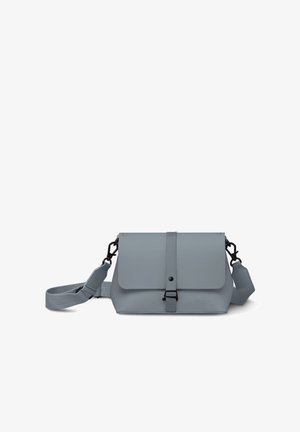 Grå crossbody-taske med justerbar rem og frontklap, der er sikret med en lodret rem og sort metalspænde.